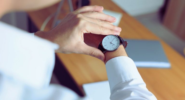 Personne en chemise consultant l heure sur sa montre-bracelet au bureau