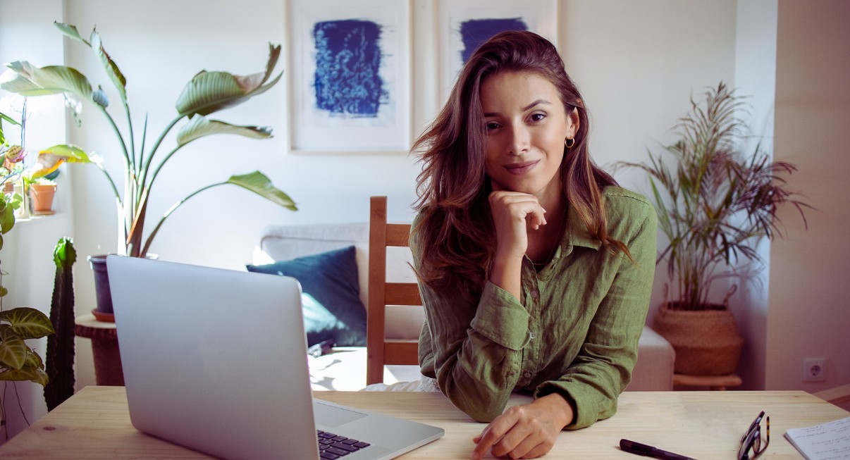 Femme travaillant a domicile devant un ordinateur portable dans un salon lumineux